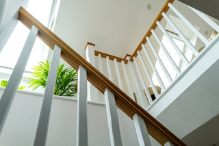 An image of a staircase with natural light shining through skylights in the background.