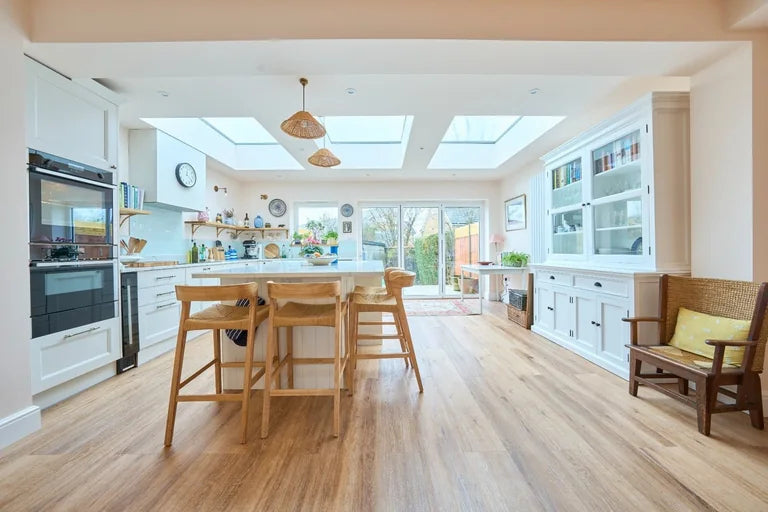 Three Cambridge frameless rooflights bring daylight into a white kitchen and dining space in Earlsfield