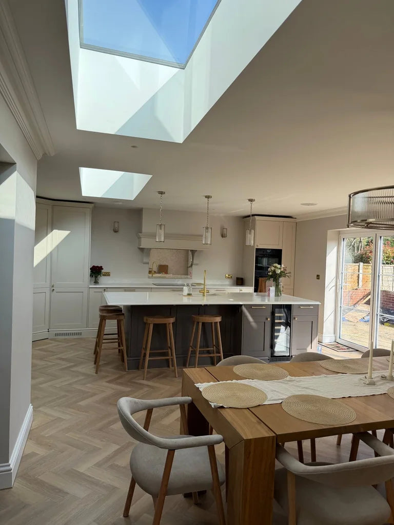 Two frameless rooflights over a kitchen extension with green cabinetry